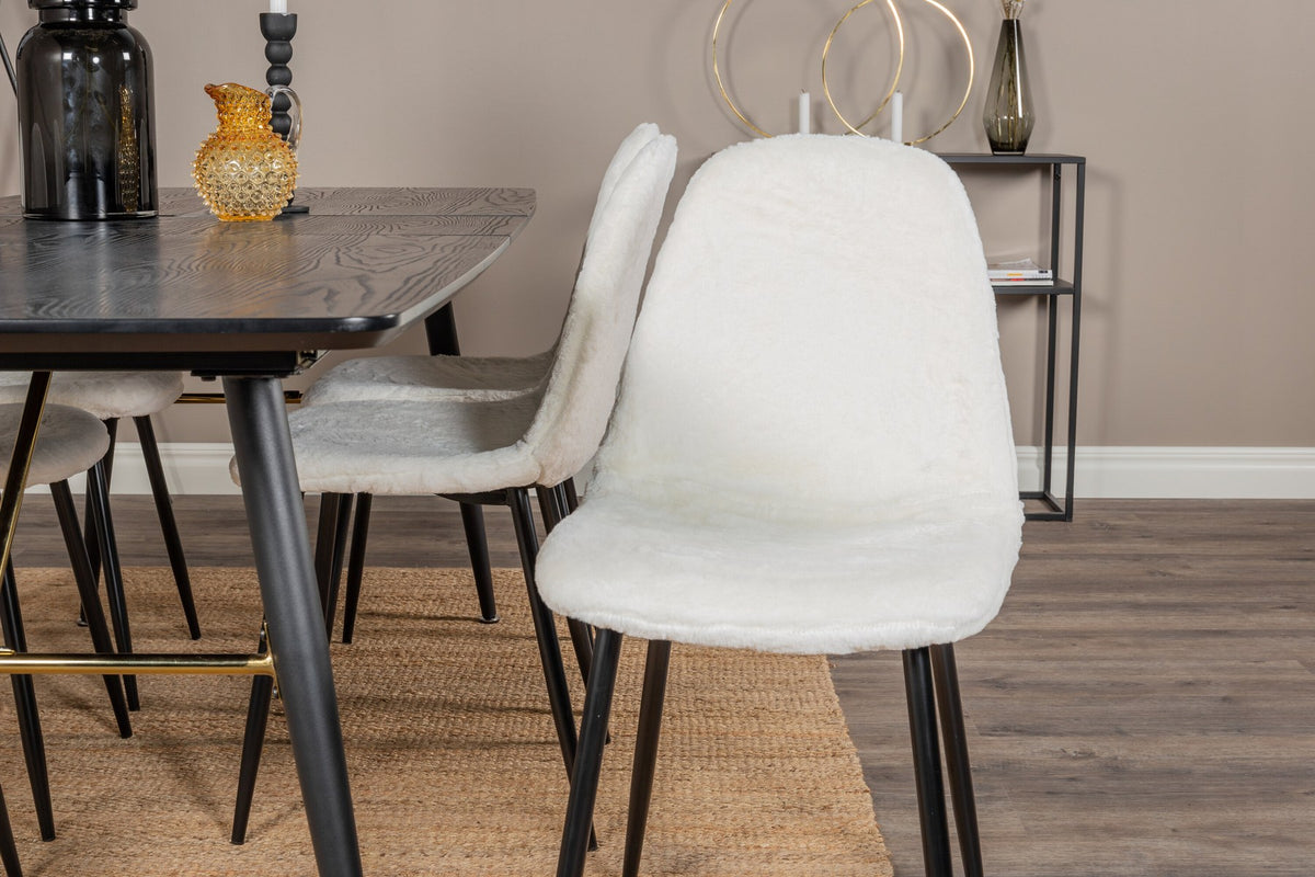 Esszimmerset mit ausziehbarem Esstisch aus MDF mit schwarzer Platte und Stahlbeinen, dazu zwei weisse Stühle aus MDF und Stahl.
