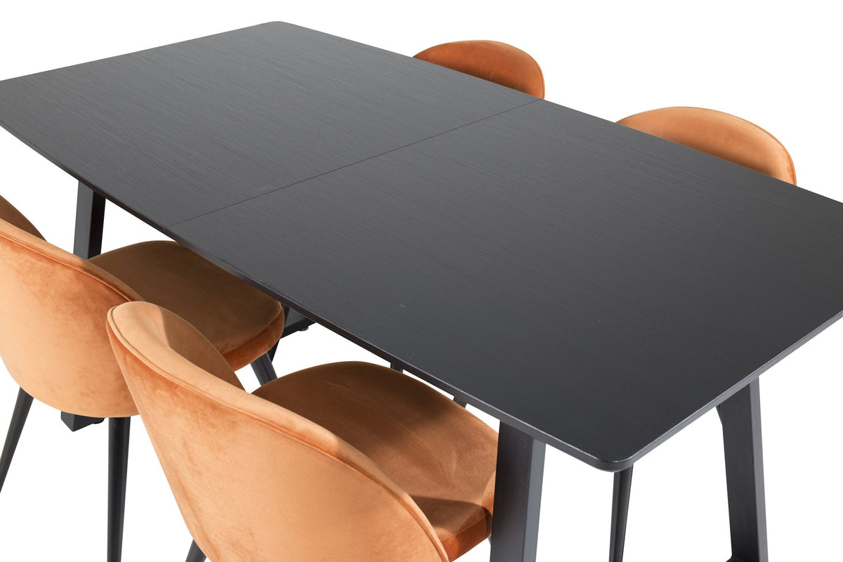 Zwei gepolsterte Esszimmerstühle in Rostorange mit schwarzem Metallgestell neben rechteckigem schwarzem Esstisch aus MDF und Stahl.