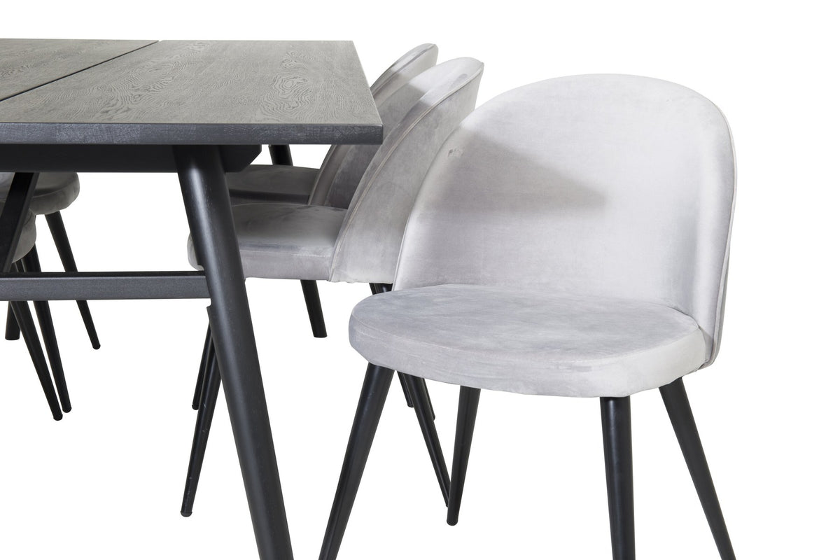 Rechteckiger Esstisch mit schwarzer Eichenplatte und Stahlbeinen, dazu zwei graue Stühle mit Stahlgestell aus dem Sleek & Velvet Set.