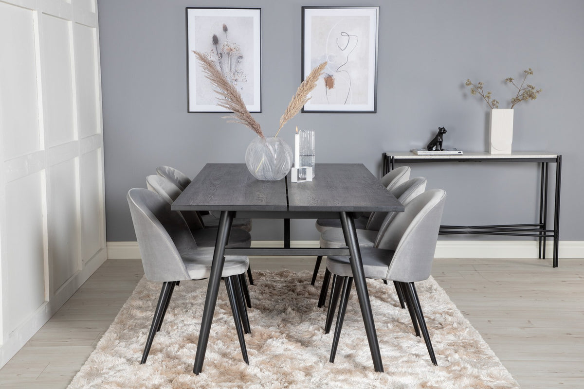 Rechteckiger Esstisch mit schwarzer Eichenplatte und Stahlbeinen, dazu zwei graue Stühle mit Stahlgestell aus dem Sleek & Velvet Set.