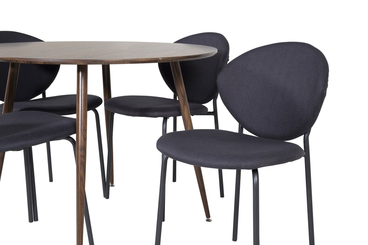Zwei schwarze Esszimmerstühle aus MDF und Stahl neben einem runden Esstisch mit Nussbaum-Tischplatte, Durchmesser 100 cm.