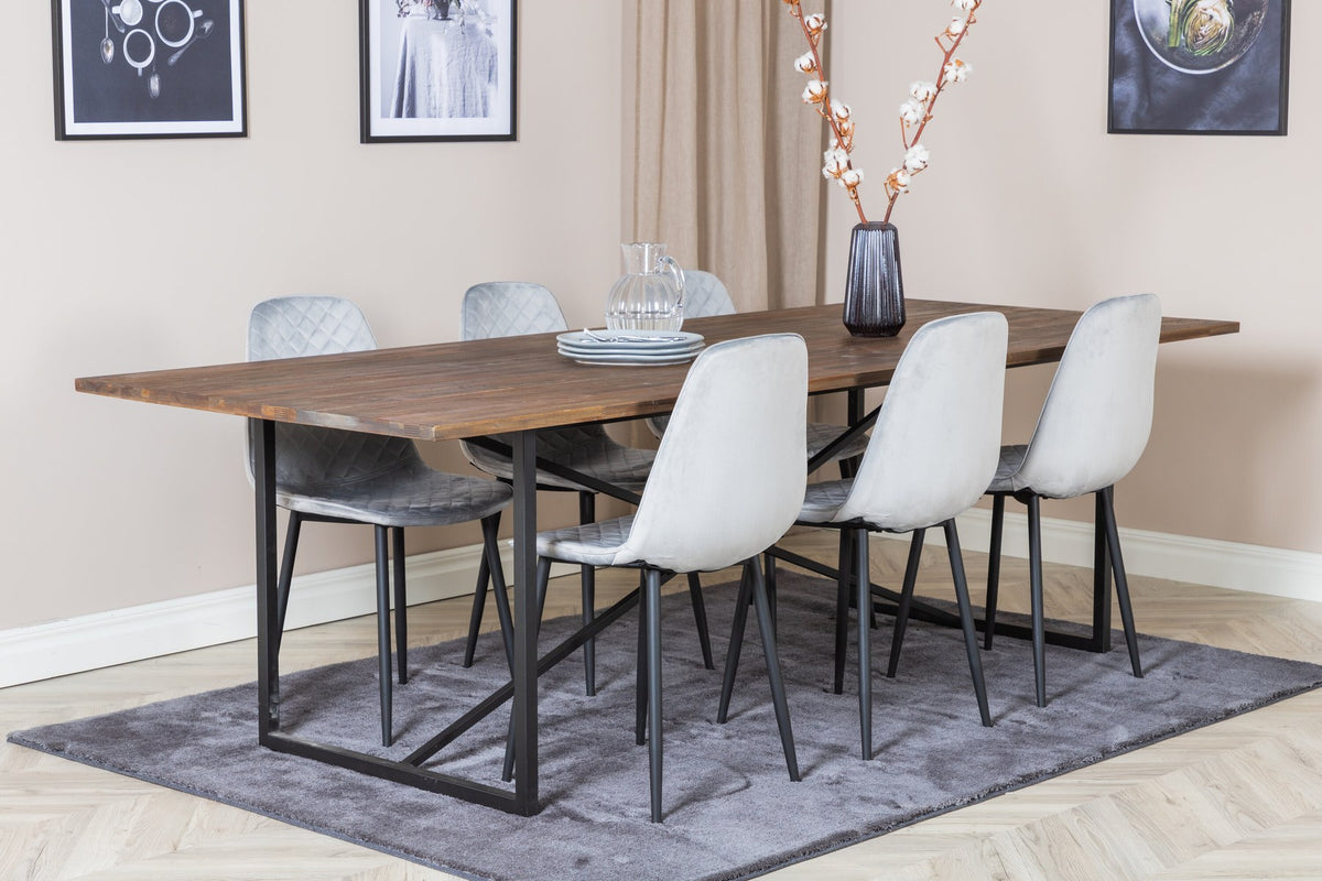 Esstisch mit Teak-Tischplatte in Natur und Stahlgestell, dazu Stühle mit schwarzem Stahlrahmen und grauem Polyester-Samt-Bezug.