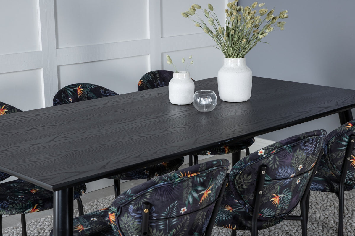 Schwarzes Esszimmerset Dipp mit Vault Stühlen: Tisch mit MDF-Furnierplatte und Stahlbeinen, Stühle mit Polsterbezug und Stahlgestell.