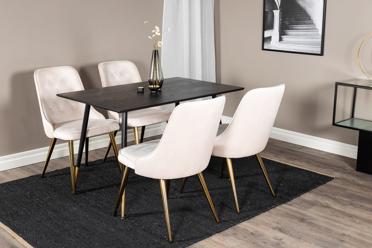 Rechteckiger Esstisch mit schwarzer MDF-Tischplatte und Stahlbeinen, daneben zwei gepolsterte Stühle in Beige mit Messing-Gestell.