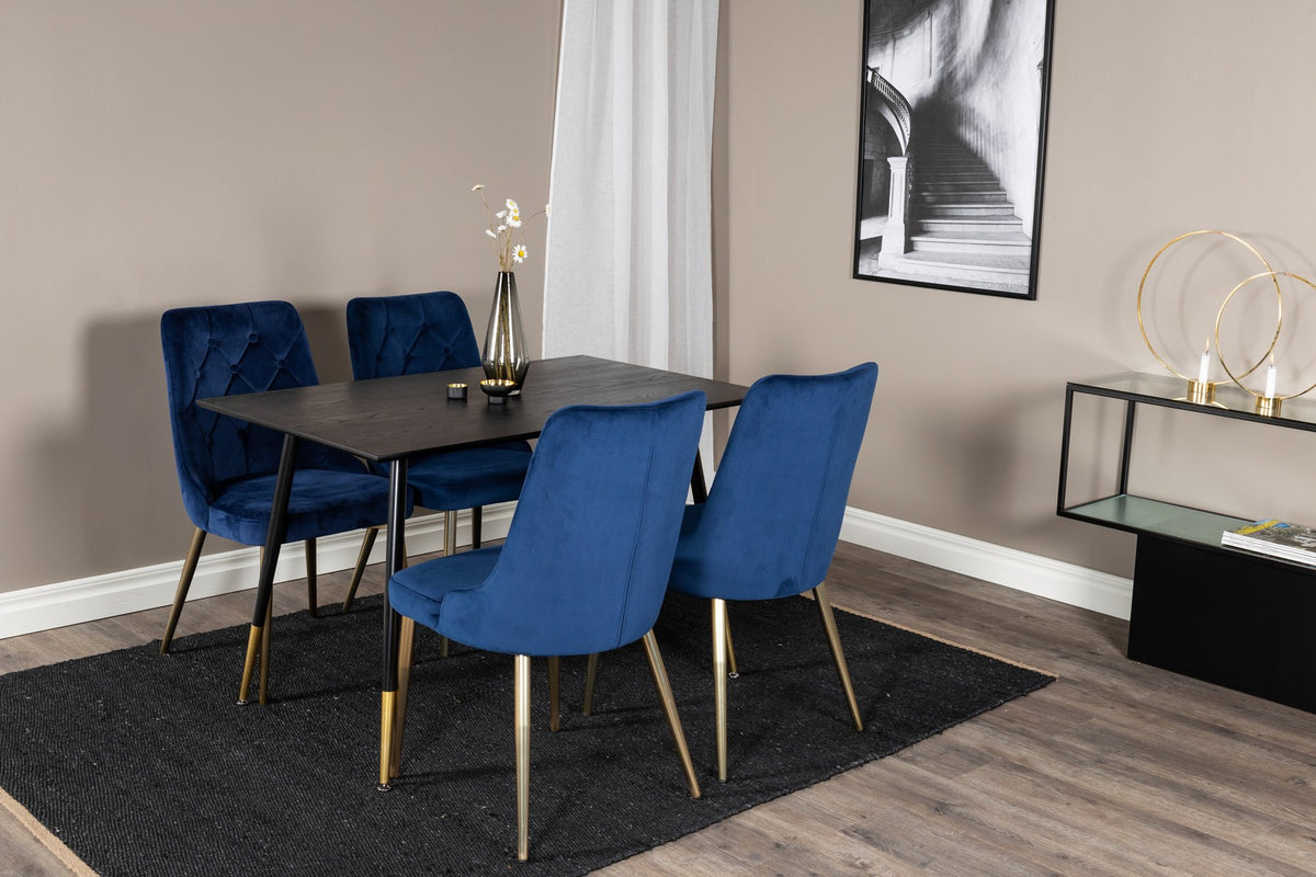 Rechteckiger Esstisch mit schwarzer MDF-Platte und Stahlbeinen, dazu zwei blaue Stühle mit messingfarbener Oberfläche im Esszimmerset.