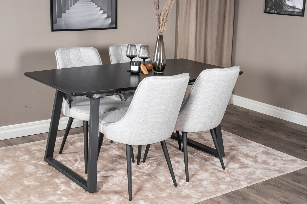 Rechteckiger Esstisch Inca in Schwarz mit ausziehbarer MDF-Platte und Stahlbeinen, daneben zwei gepolsterte Velvet-Esszimmerstühle in Grau von Venture Home.