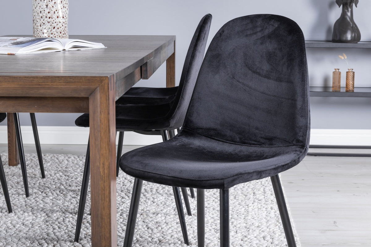 Rechteckiger Esstisch aus Eiche in Natur mit ausziehbarer Platte, dazu zwei schwarze Esszimmerstühle mit gepolsterter Sitzfläche von Venture Home.