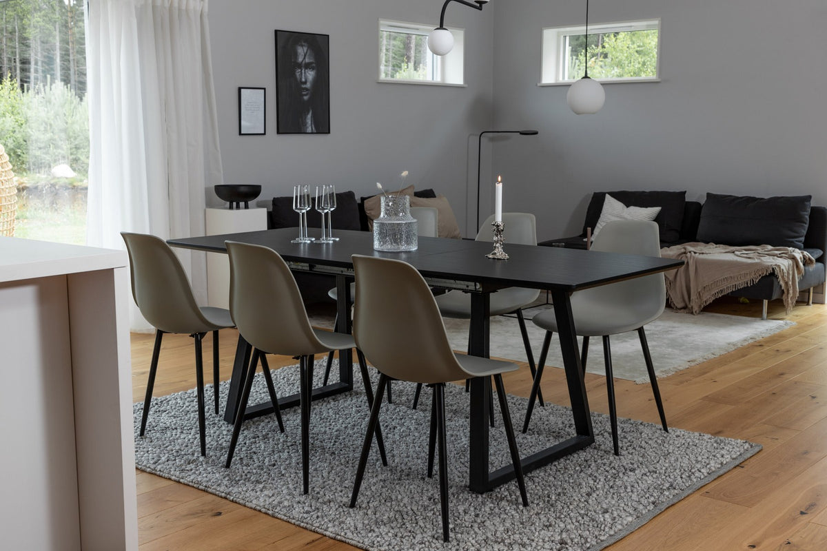 Grauer Esstisch mit schwarzer Tischplatte aus MDF und Stahl, dazu vier Esszimmerstühle mit schwarz pulverbeschichtetem Gestell.