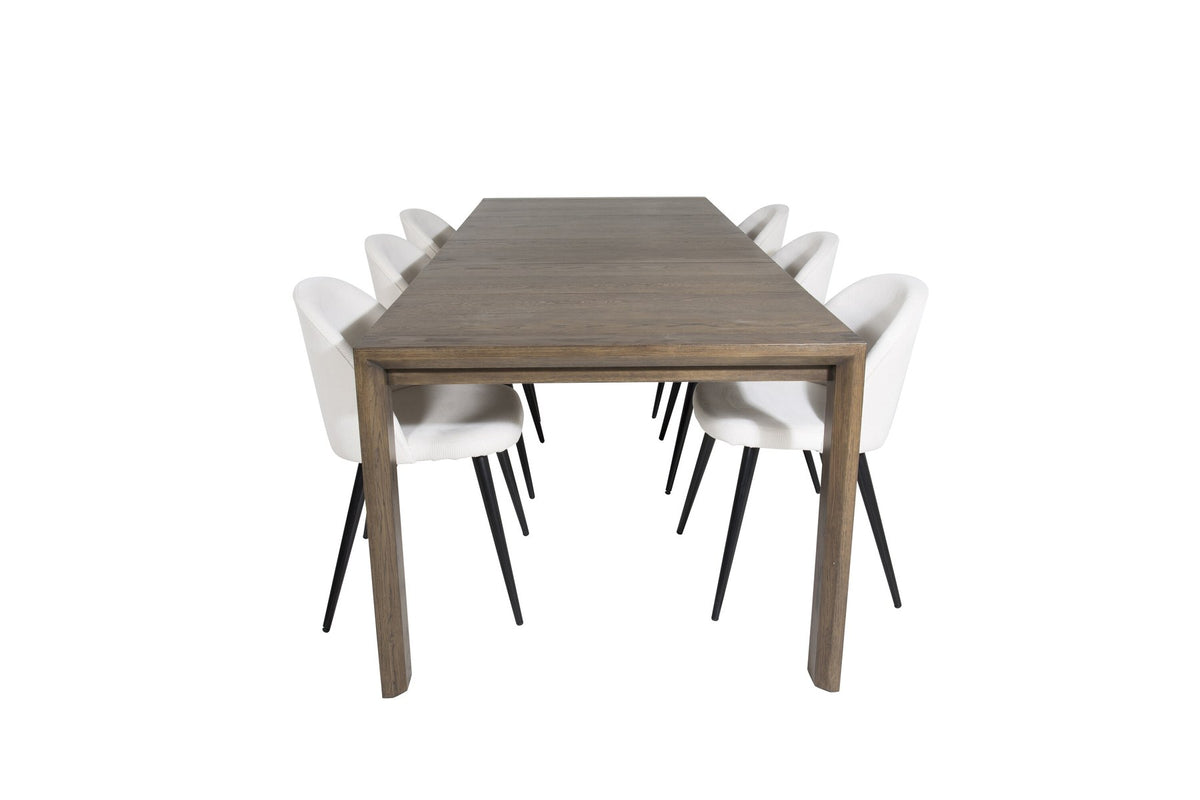 Esstisch mit heller Holzplatte in Naturfarbton auf Eichen-Gestell, umgeben von cremefarbenen Polsterstühlen aus Samt der Velvet-Serie.