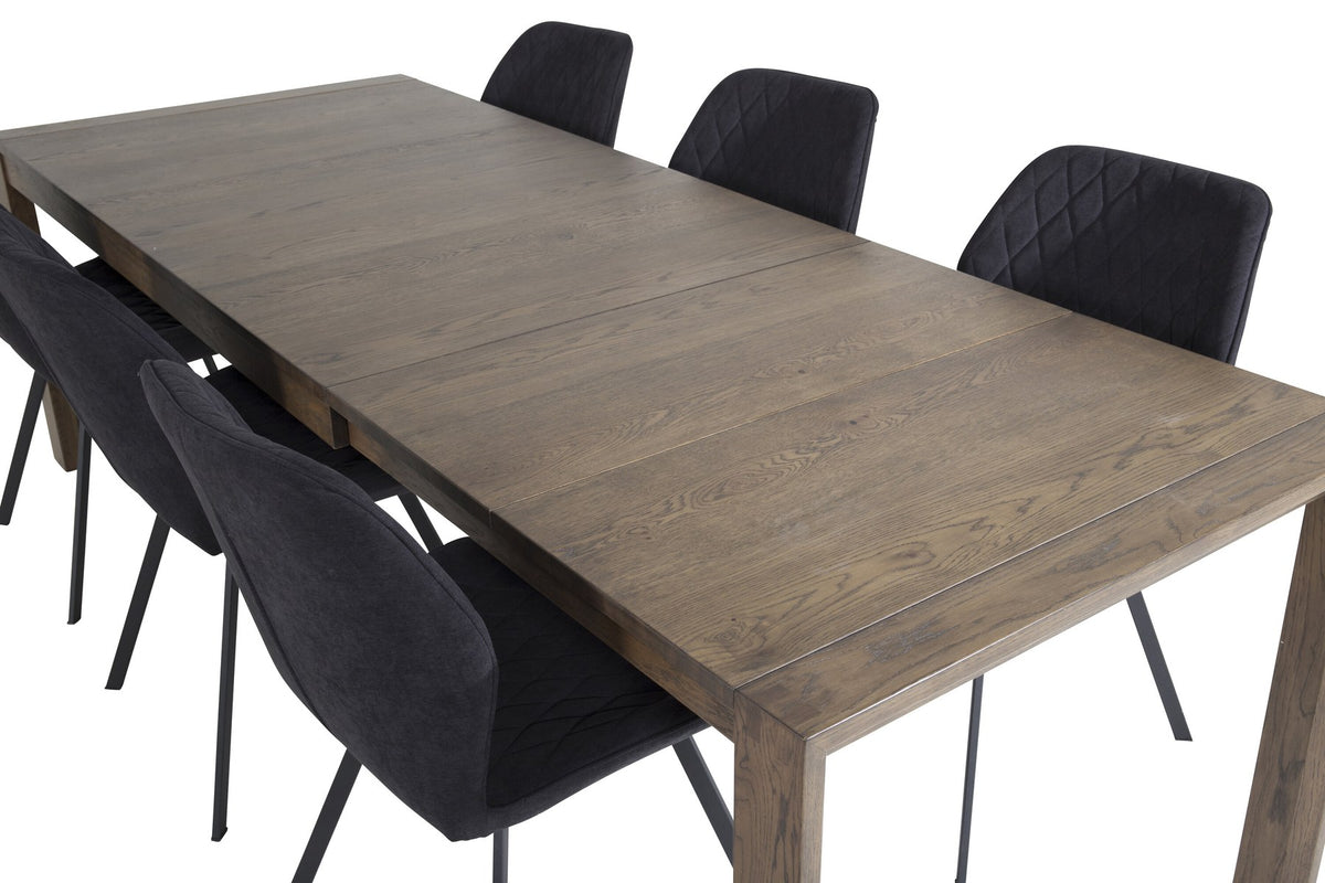 Rechteckiger Esstisch aus Eiche in Naturfarbe mit ausziehbarer Tischplatte, kombiniert mit zwei schwarzen Esszimmerstühlen im Set.