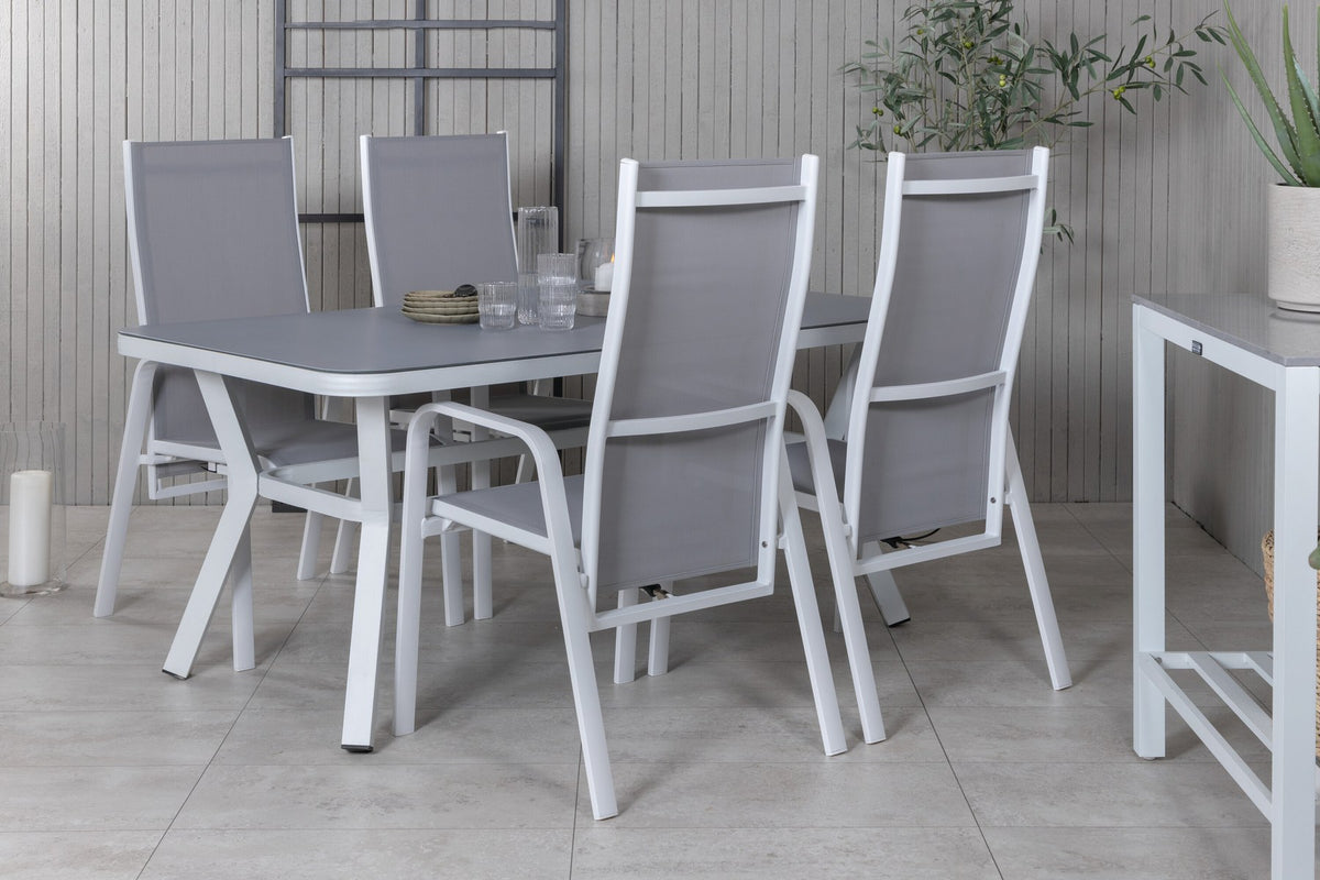 Rechteckiger Esstisch mit grauem Gestell und schwarzer Mattglas-Tischplatte, daneben zwei graue Relaxsessel aus Textilene mit Aluminiumbeinen.