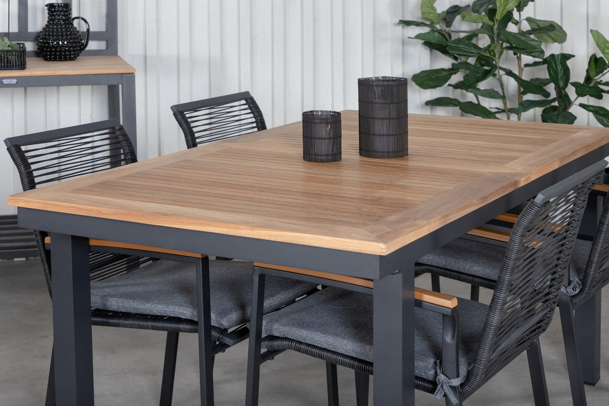 Zwei schwarze Aluminium-Stühle mit Polyester-Bezug und ein rechteckiger, ausziehbarer Teak-Tisch mit schwarzer Tischplatte.