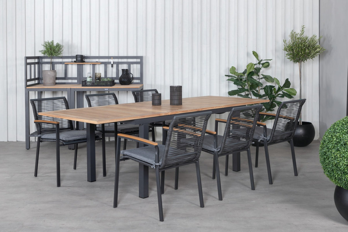 Zwei schwarze Aluminium-Stühle mit Polyester-Bezug und ein rechteckiger, ausziehbarer Teak-Tisch mit schwarzer Tischplatte.