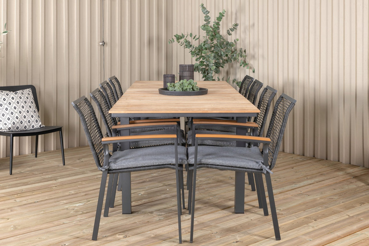 Foto eines schwarzen 2er-Stuhlsets mit Aluminiumgestell und Polyesterbezug neben einem rechteckigen Teak-Esstisch in Natur mit Stahlbeinen.
