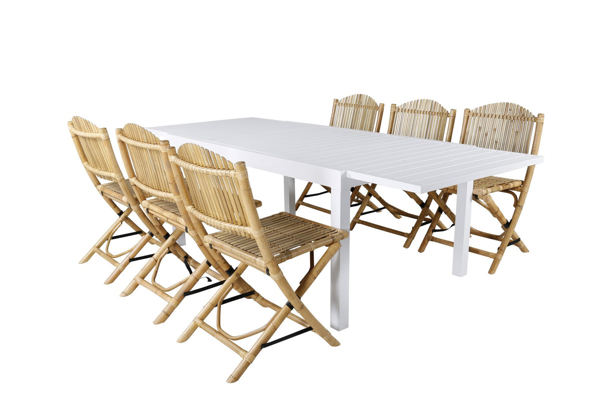 Aluminium-Caféstuhl in Natur mit Baumwoll-Polyester-Bezug neben rechteckigem Esstisch mit weisser Aluminium-Tischplatte und Rattanbeinen.