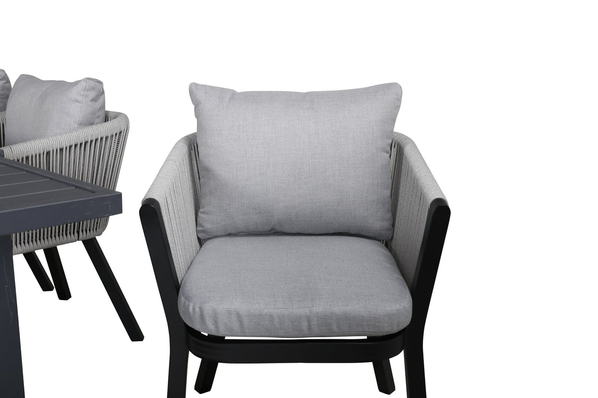 Gartentischset aus Aluminium: ausziehbarer Marbella Tisch mit schwarzem Gestell und 4 Virya Stühlen mit grauem Kissen im Aussenbereich.