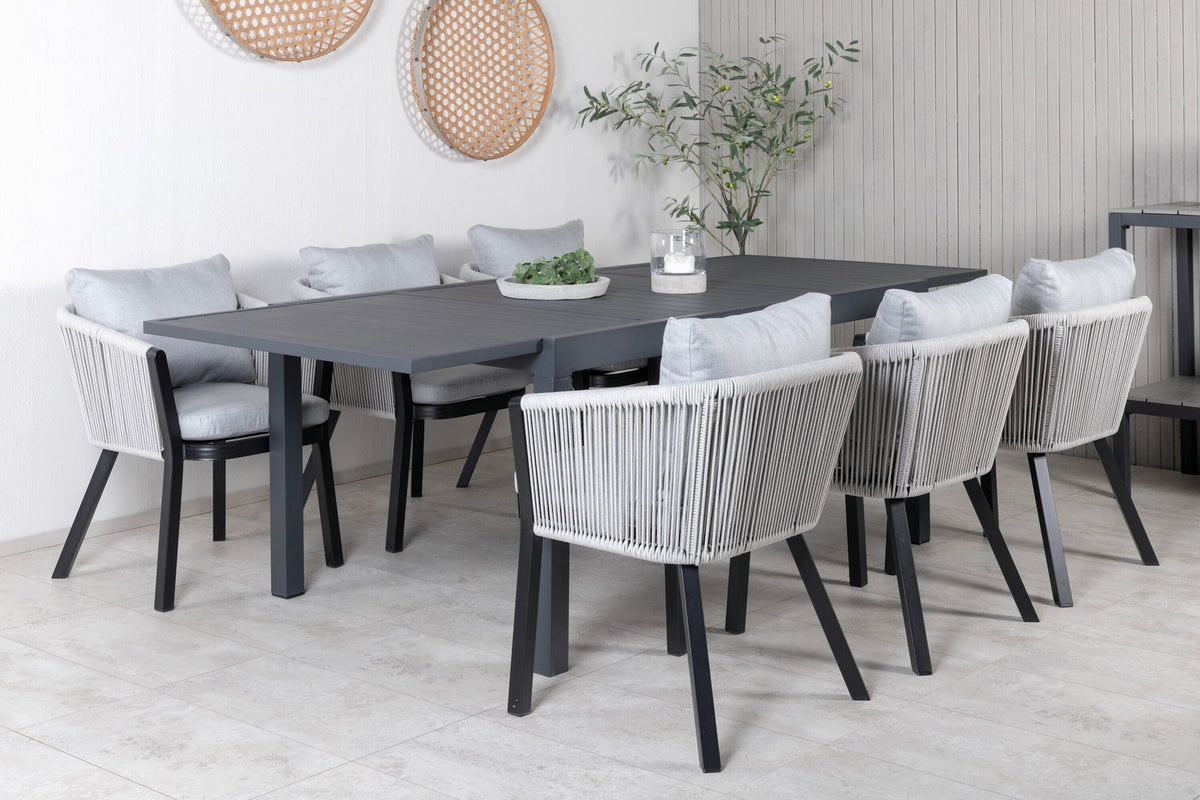 Gartentischset aus Aluminium: ausziehbarer Marbella Tisch mit schwarzem Gestell und 4 Virya Stühlen mit grauem Kissen im Aussenbereich.
