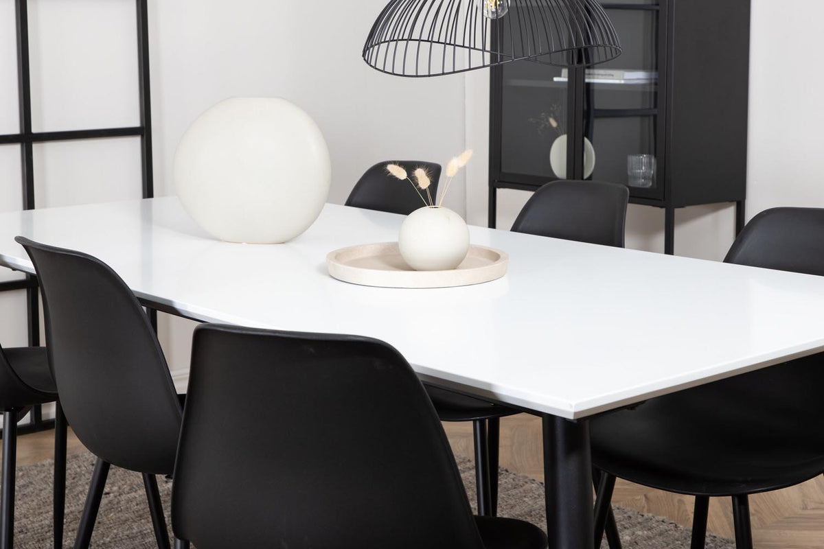 Esszimmerset Jimmy mit ausziehbarem Tisch aus weissem HPL und MDF, schwarzen Stahlbeinen sowie sechs schwarzen Polar-Stühlen mit Kunststoffsitz.