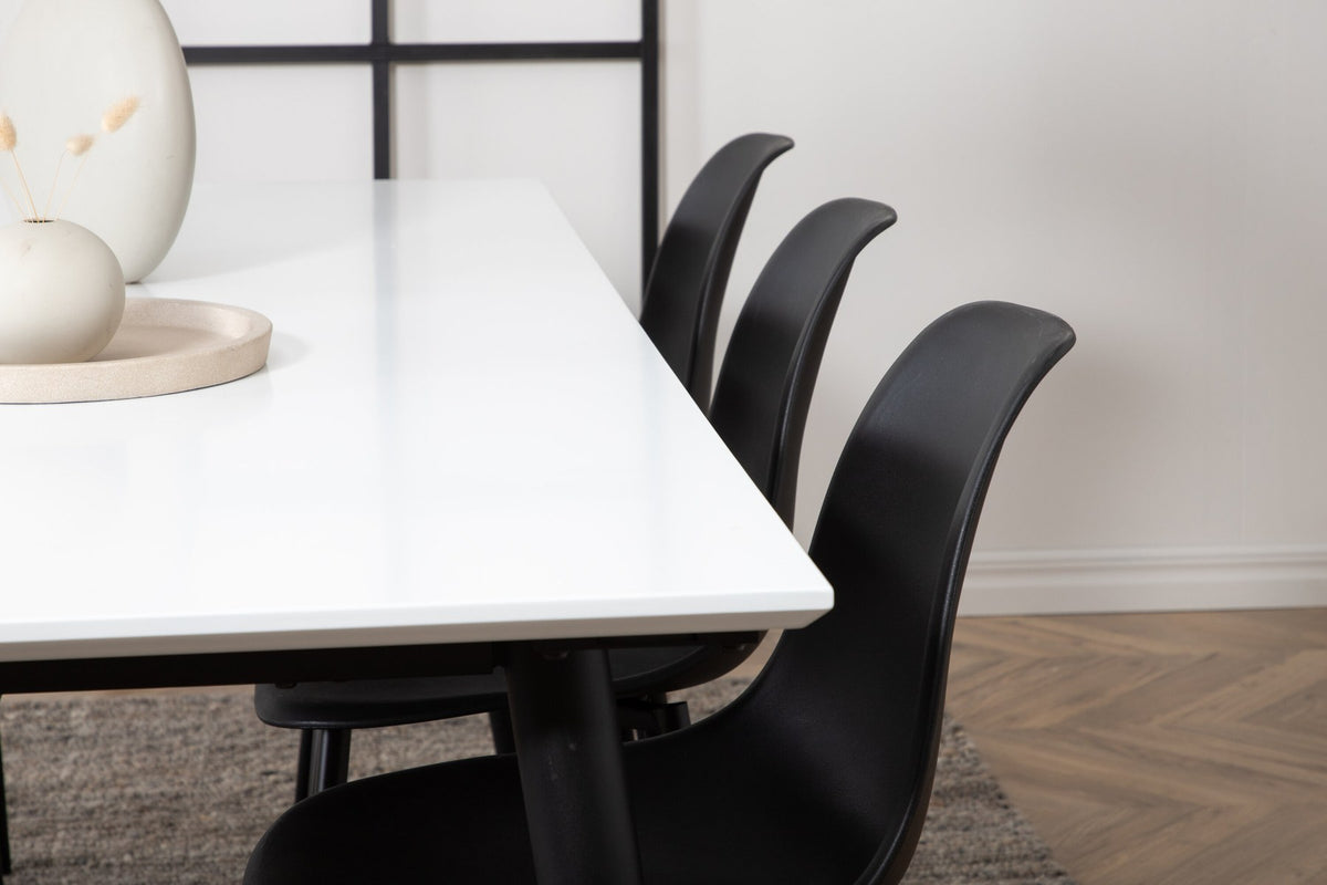 Esszimmerset Jimmy mit ausziehbarem Tisch aus weissem HPL und MDF, schwarzen Stahlbeinen sowie sechs schwarzen Polar-Stühlen mit Kunststoffsitz.