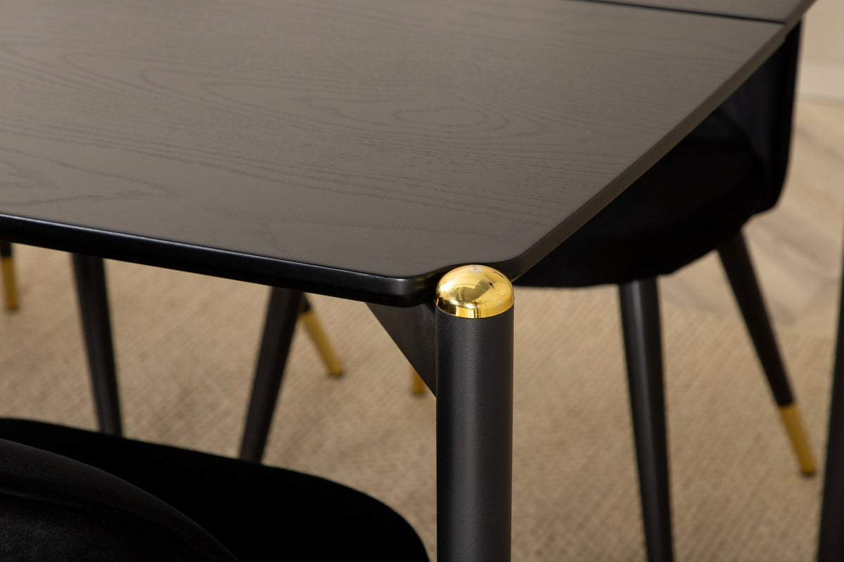 Schwarzer Esstisch aus MDF mit Furnier und Stahlbeinen, kombiniert mit sechs schwarzen Samtstühlen mit gepolstertem Sitz und Metallbeinen.