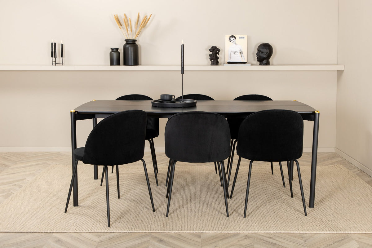 Esszimmerset Pelle mit schwarzem MDF-Tisch und sechs gepolsterten Wrinkles-Stühlen aus schwarzem Samt und Metallbeinen aus Stahl.