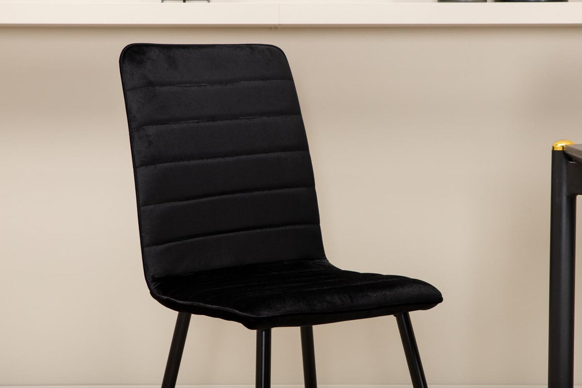 Esszimmerset Pelle mit schwarzem MDF-Tisch mit Furnier und sechs Windu Stühlen aus schwarzem Samt mit Metallgestell und Kissen.