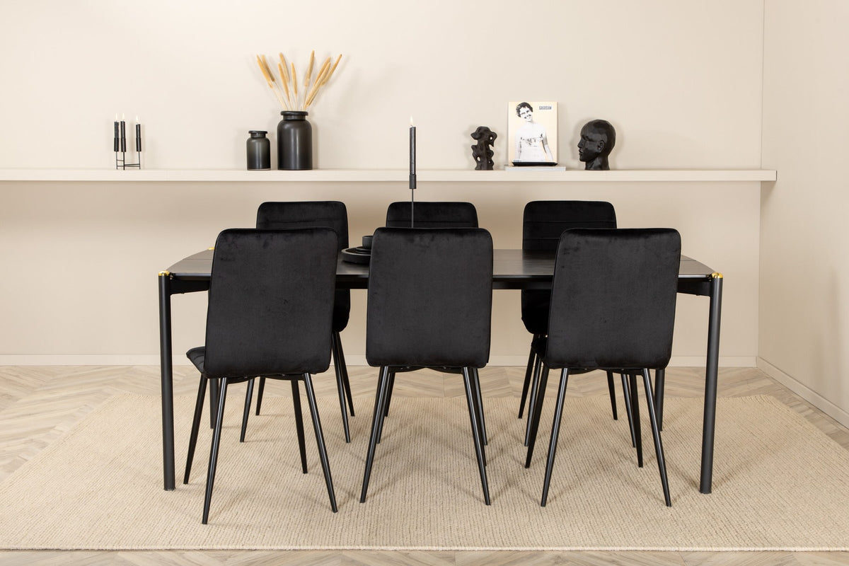 Esszimmerset Pelle mit schwarzem MDF-Tisch mit Furnier und sechs Windu Stühlen aus schwarzem Samt mit Metallgestell und Kissen.