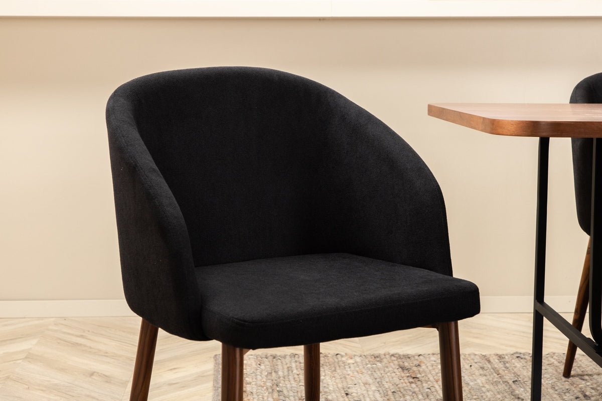 Esszimmerset Uno: rechteckiger Tisch mit MDF-Furnier-Platte in Nussbaum und schwarzem Stahlgestell, dazu Arch Stühle mit Polyesterbezug.