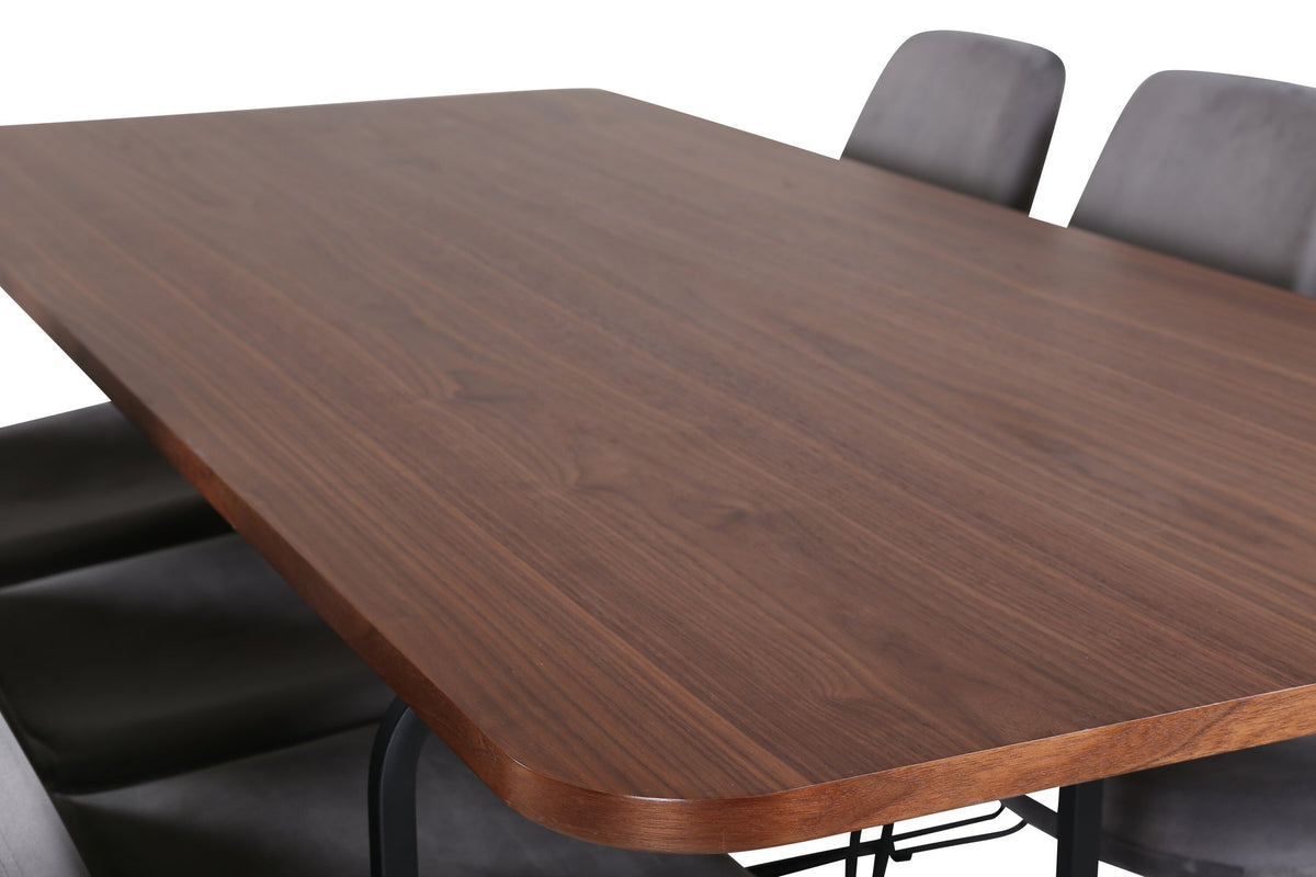 Rechteckiger Esstisch mit Nussbaum-Tischplatte aus MDF und Furnier, Stahlgestell, umgeben von sechs grauen Samtstühlen mit schwarzem Stahlgestell.
