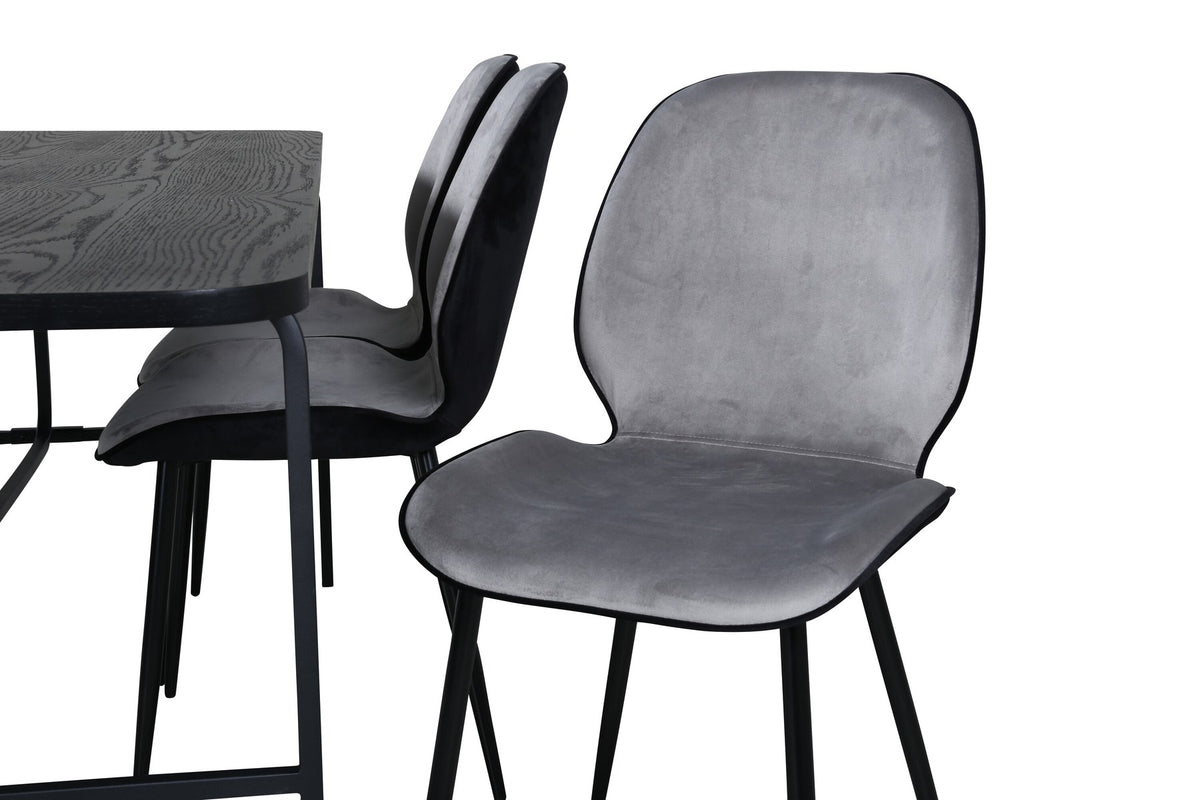 Zwei graue Esszimmerstühle mit Samtbezug und Eisenbeinen neben einem rechteckigen schwarzen Esstisch aus MDF mit Furnier und Metallgestell.