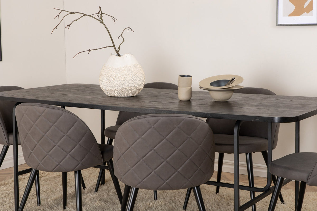 Esszimmerset Uno & Velvet: rechteckiger Esstisch mit schwarzer MDF-Furnier-Platte und Metallgestell, dazu Stühle mit grauem Samtbezug und Eisenbeinen.