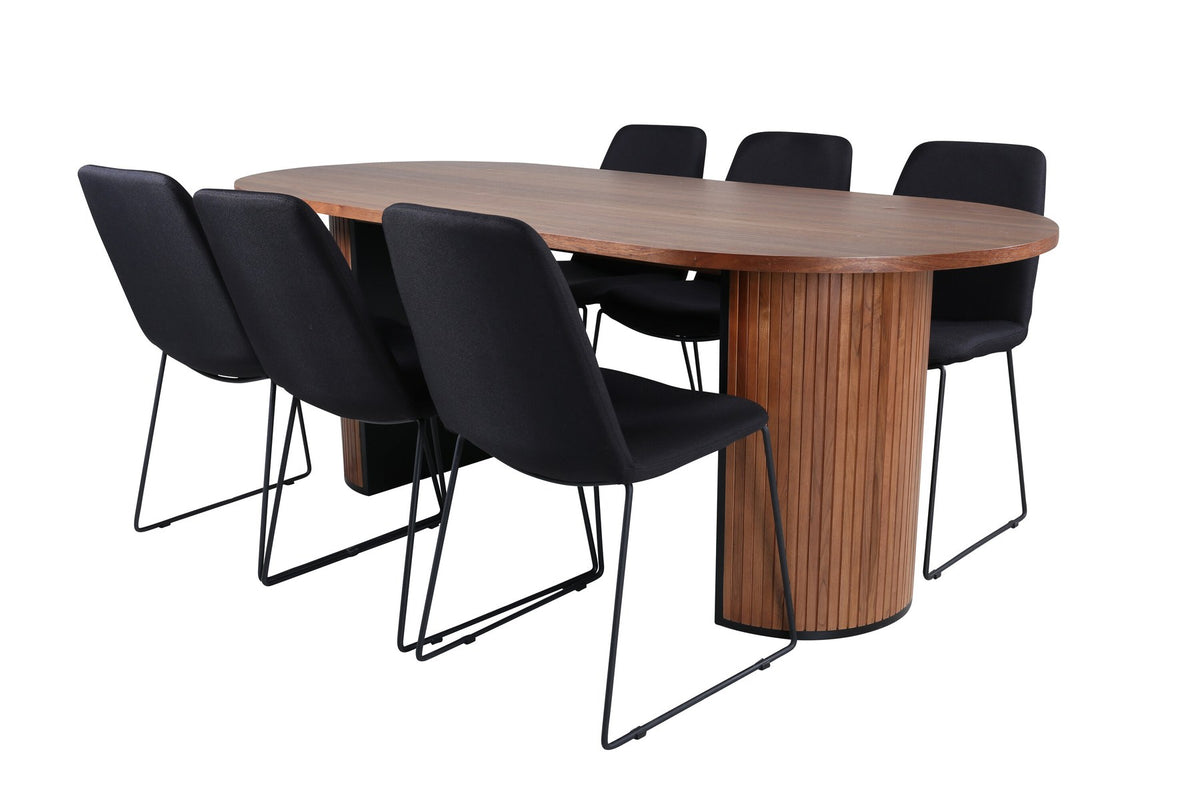 Ovaler Esstisch mit Nussbaum-Furnier und MDF-Platte, kombiniert mit zwei schwarzen Esszimmerstühlen mit Polyesterbezug und schmalen Stahlbeinen.