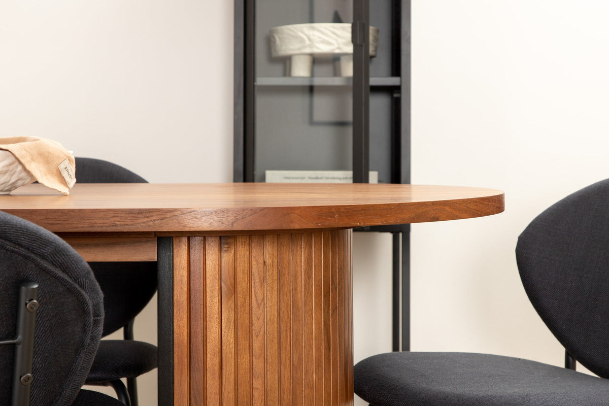 Ovaler Esstisch aus Nussbaum-MDF mit Furnier und Stahlbeinen, dazu zwei schwarze Polsterstühle mit Metallbeinen im Set.