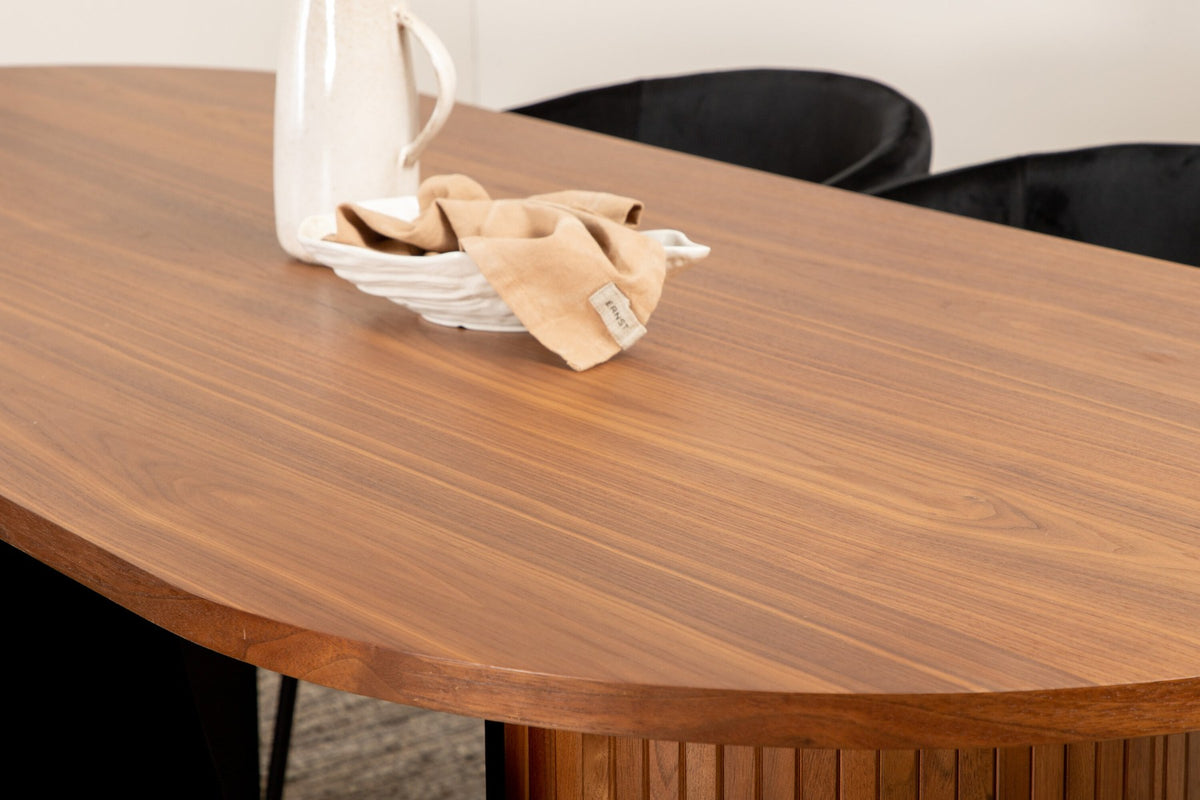 Ovaler Esstisch aus Nussbaum-MDF mit Furnier und vier schwarzen Esszimmerstühlen mit Samtsitz und schmalen Eisenbeinen von Venture Home.