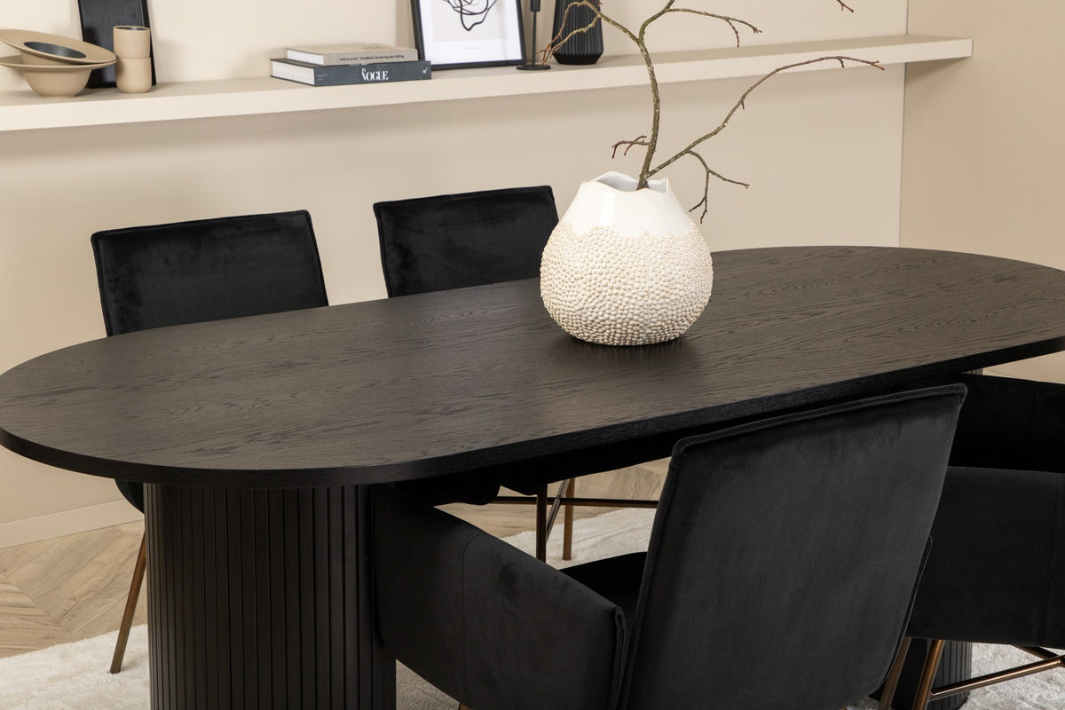Ovaler Esstisch 200x90 cm aus MDF mit schwarzem Furnier und vier Esszimmerstühle mit kupferfarbenen Beinen und schwarzem Samtbezug.