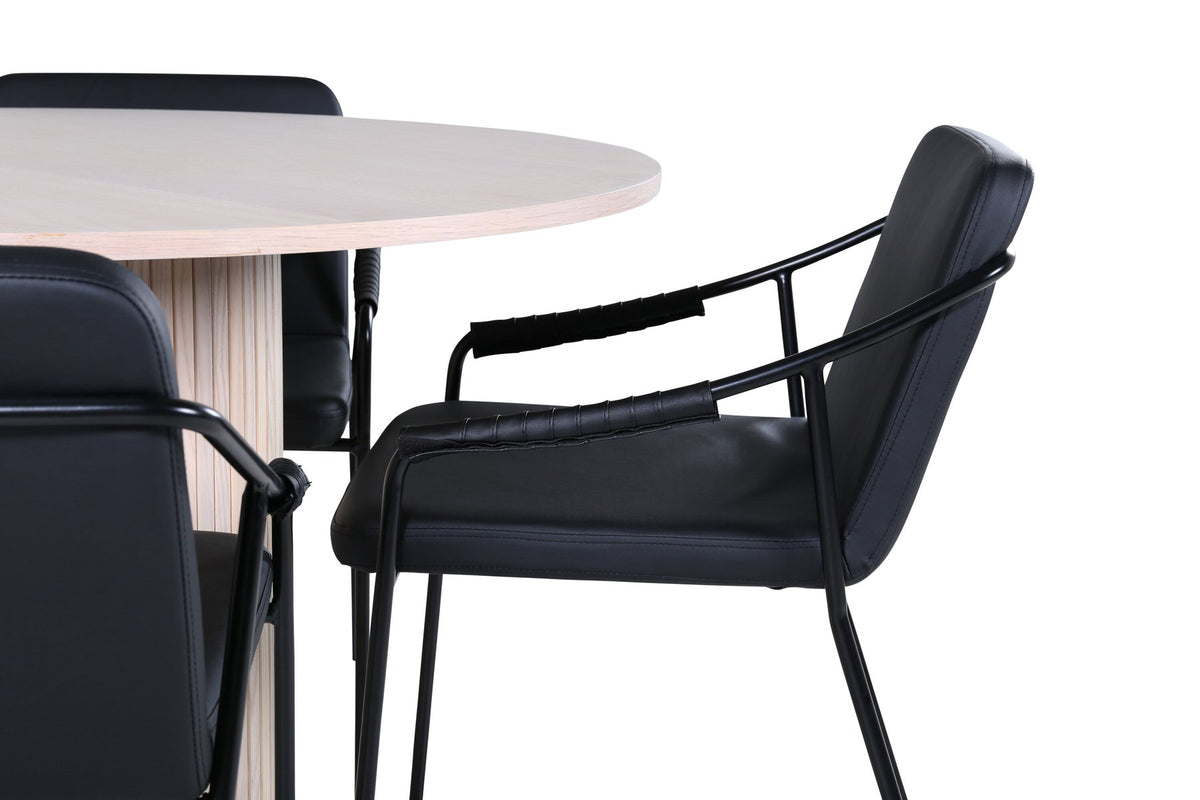 Rundes Esszimmerset aus MDF: Tischplatte Ø110 cm in Whitewash mit gerippten Beinen, dazu zwei schwarze Stühle mit Eisenbeinen.