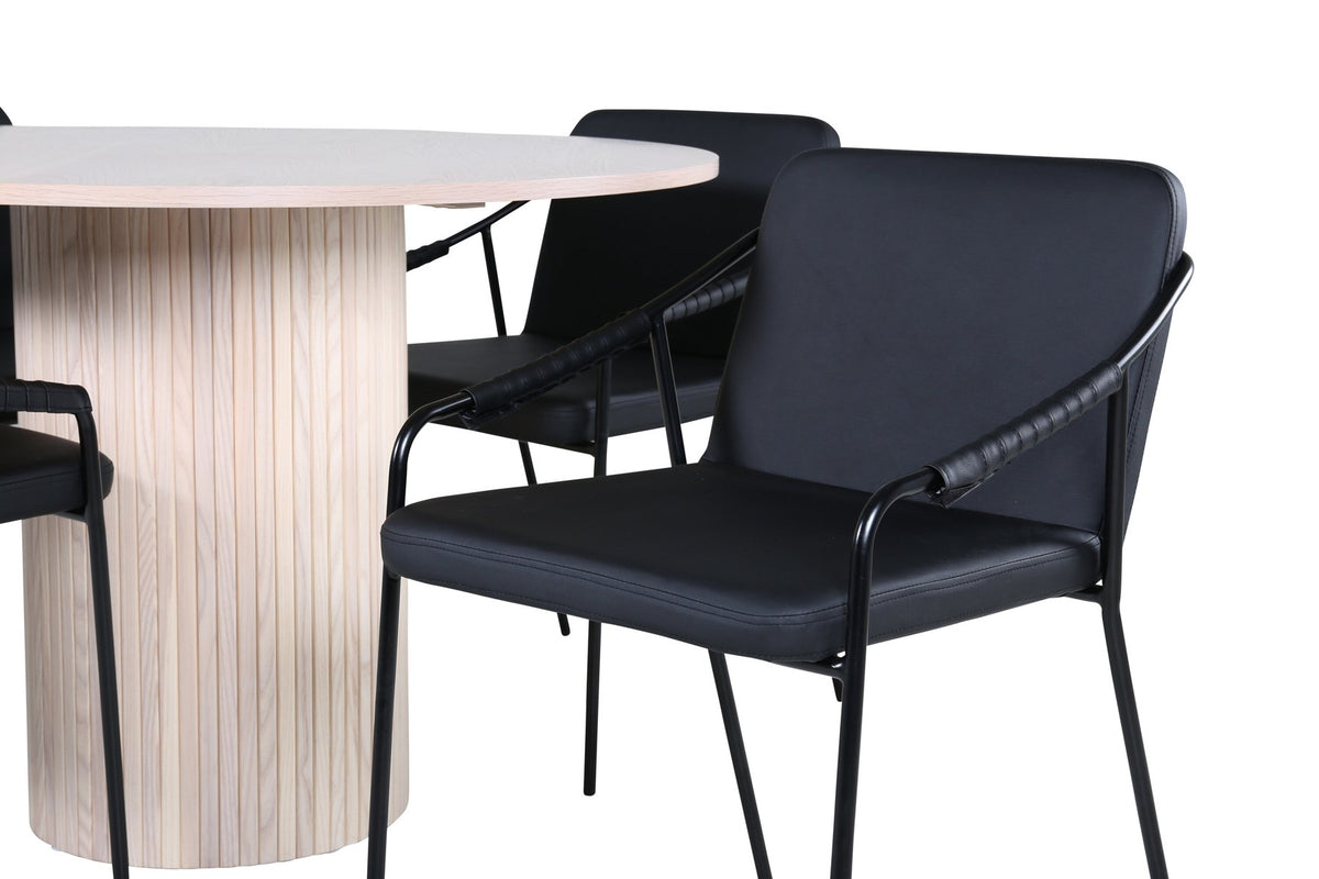 Rundes Esszimmerset aus MDF: Tischplatte Ø110 cm in Whitewash mit gerippten Beinen, dazu zwei schwarze Stühle mit Eisenbeinen.