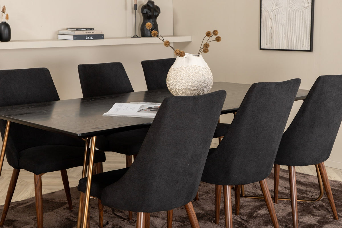 Rechteckiger Esstisch aus schwarzem MDF mit Furnier und Stahlbeinen, dazu zwei Esszimmerstühle mit schwarzer Sitzfläche und Metallgestell.