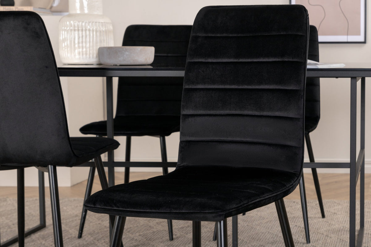 Rechteckiger Esstisch mit schwarzer Glasplatte und Metallgestell sowie zwei Esszimmerstühle mit schwarzem Samtbezug und Eisenbeinen.