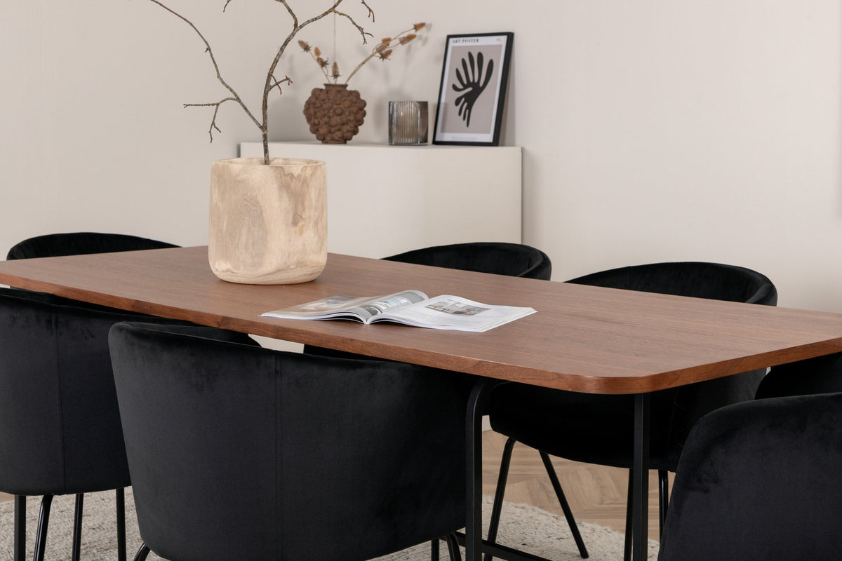 Esstisch mit Platte aus MDF und Walnussfurnier, schwarzem Metallgestell, kombiniert mit sechs Berit-Stühlen aus beigem Samtstoff und schwarzen Beinen.