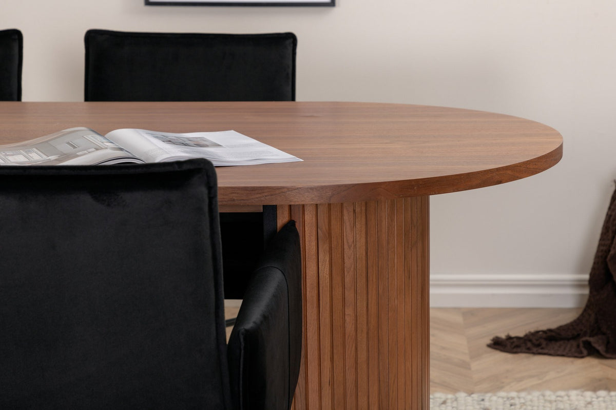 Ovaler Esstisch aus MDF mit Nussbaum-Furnier, 200x90 cm, kombiniert mit vier schwarzen Esszimmerstühlen mit pulverbeschichteter Oberfläche.