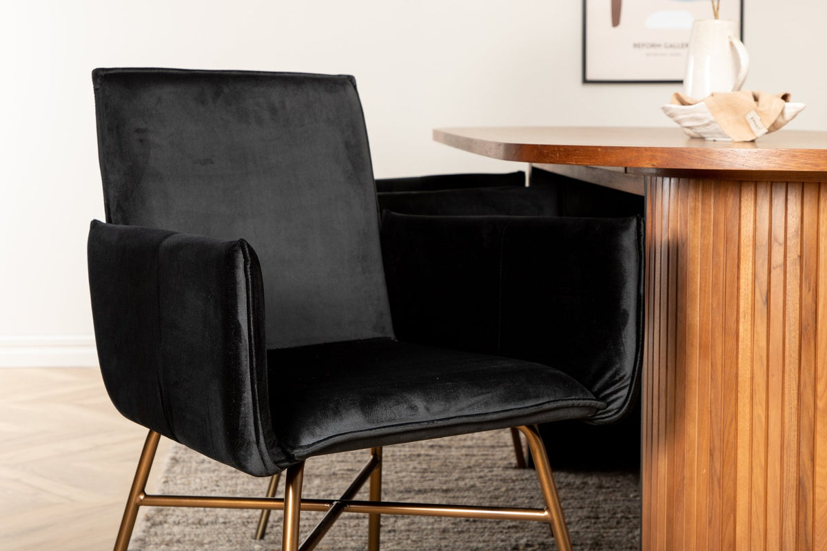 Ovaler Esstisch aus MDF mit Nussbaum-Furnier, 200x90 cm, kombiniert mit vier schwarzen Esszimmerstühlen mit pulverbeschichteter Oberfläche.