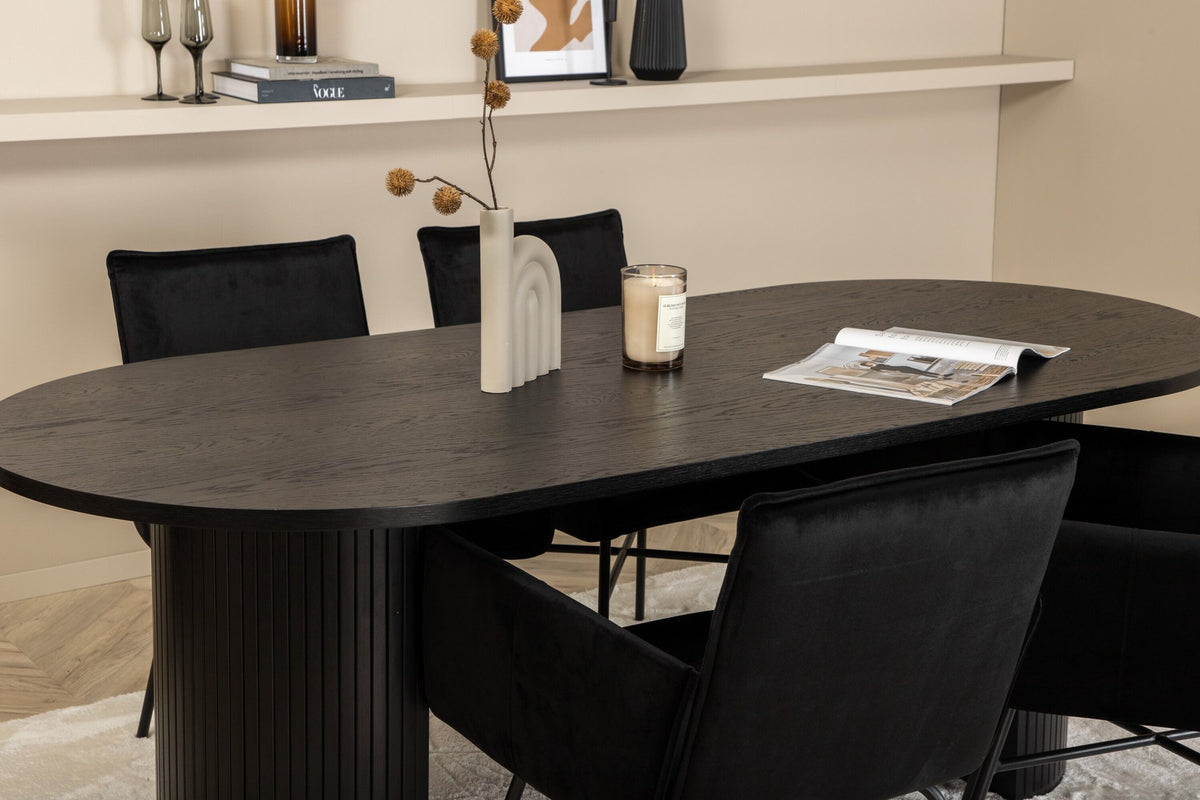 Ovaler Esstisch 200x90 cm aus MDF mit schwarzem Furnier und vier Esszimmerstühle mit kupferfarbenen Beinen und schwarzem Samtbezug.