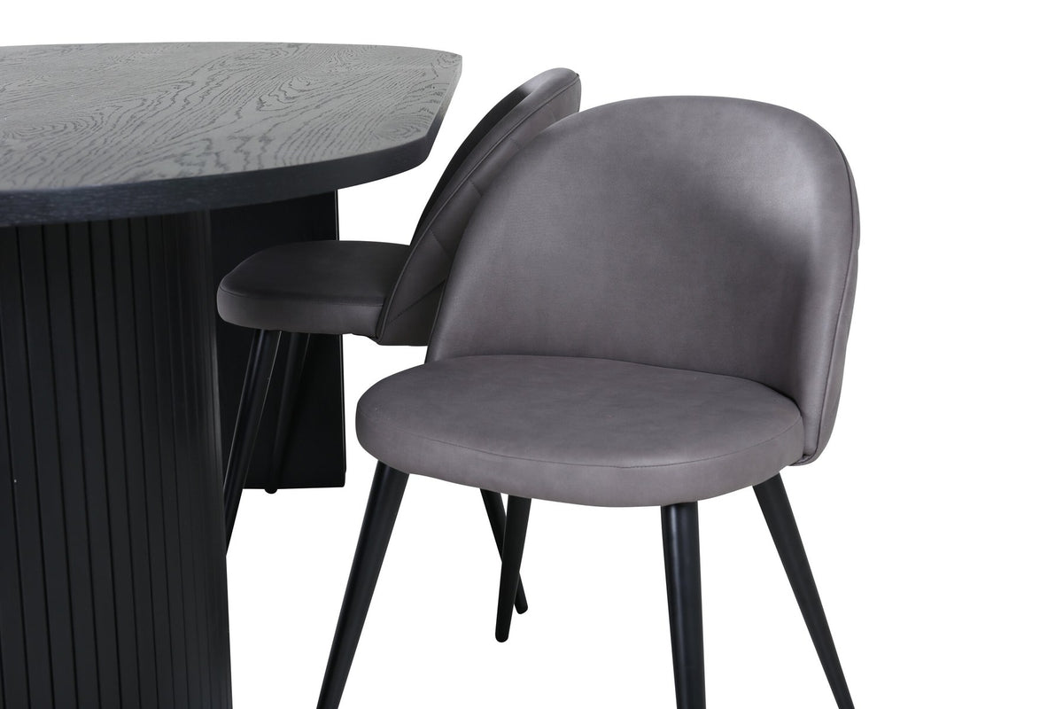 Ovaler Esstisch aus MDF mit schwarzer Furnier-Tischplatte und zwei Esszimmerstühlen mit grauem Mikrofaser-Sitz und Eisenbeinen.