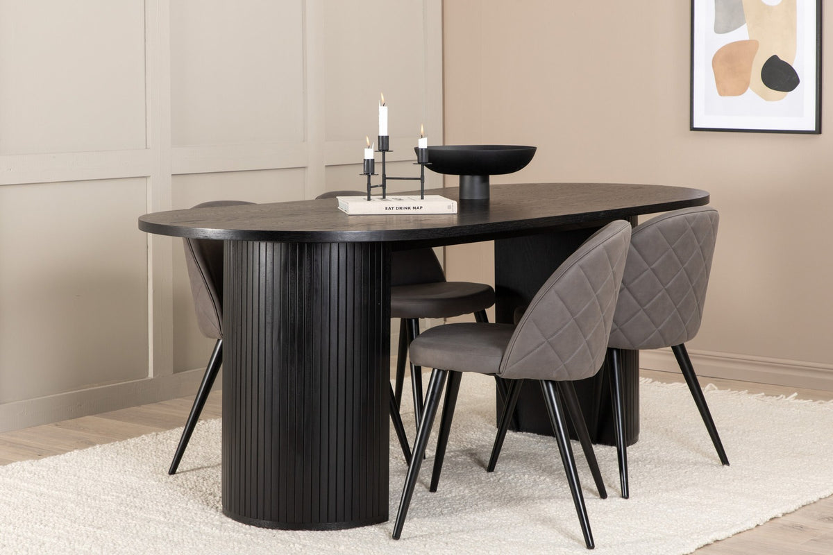 Ovaler Esstisch aus MDF mit schwarzer Furnier-Tischplatte und zwei Esszimmerstühlen mit grauem Mikrofaser-Sitz und Eisenbeinen.