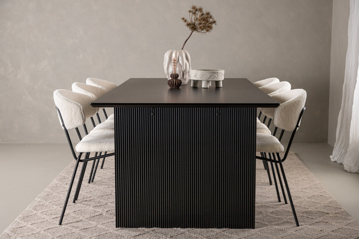 Esszimmerset aus rechteckigem MDF-Tisch in Rauchschwarz mit sechs Limhamn-Stühlen, beiger Samtbezug, muschelförmige Rückenlehne, schwarze Metallbeine.