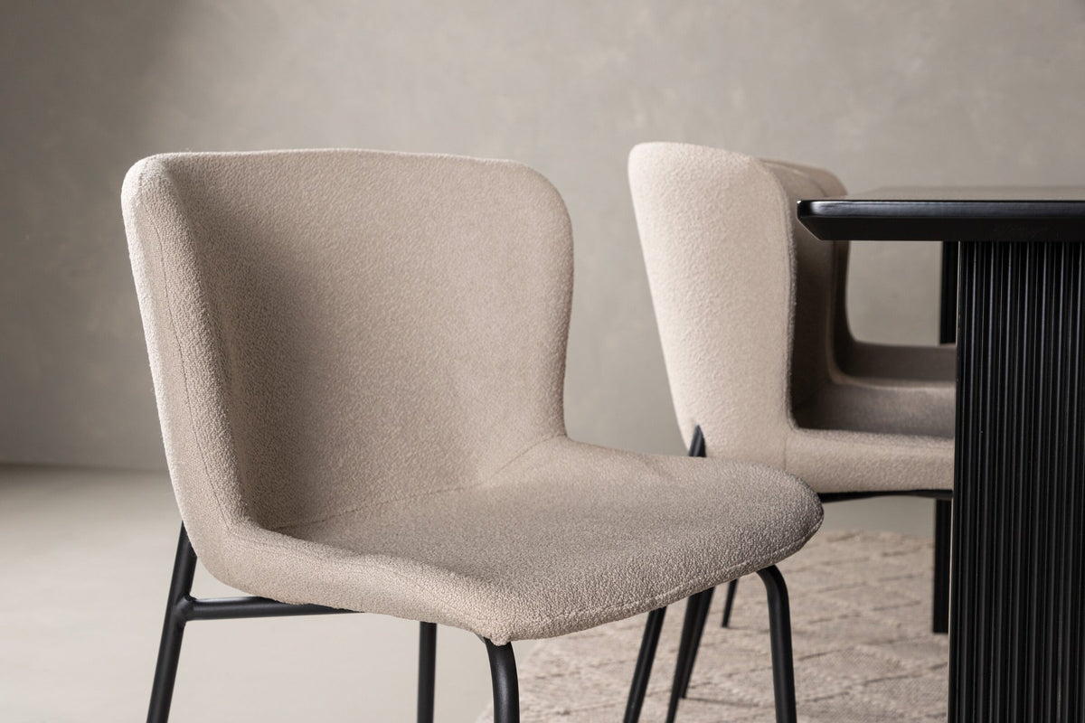 Esszimmerset aus rechteckigem MDF-Tisch in Rauchschwarz mit sechs Limhamn-Stühlen, beiger Samtbezug, muschelförmige Rückenlehne, schwarze Metallbeine.