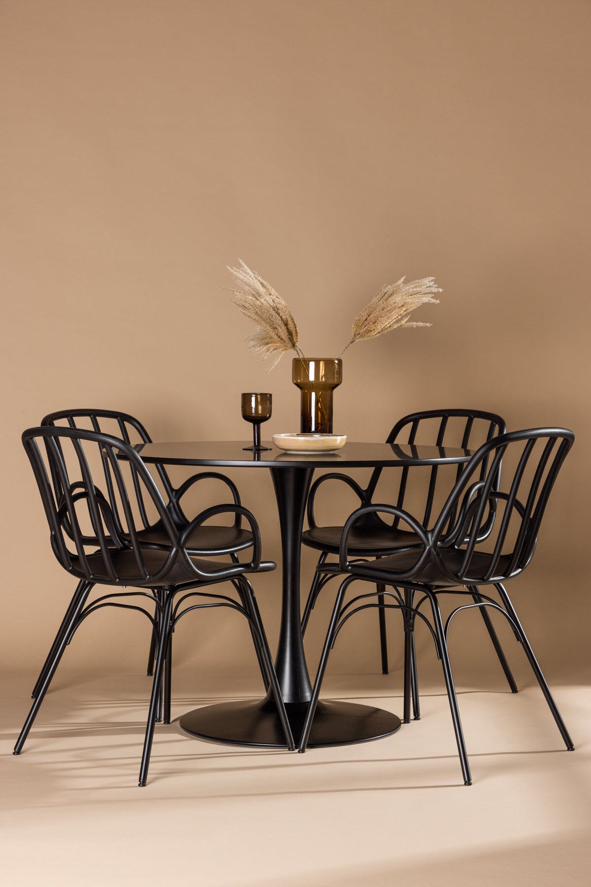 Schwarzes Esszimmerset Glade mit rundem MDF-Tisch und vier Dyrön-Stühlen aus Kunststoff und Stahl, skandinavisches Design.