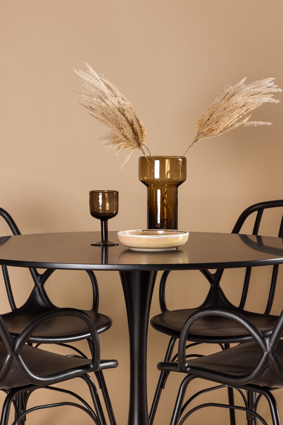 Schwarzes Esszimmerset Glade mit rundem MDF-Tisch und vier Dyrön-Stühlen aus Kunststoff und Stahl, skandinavisches Design.