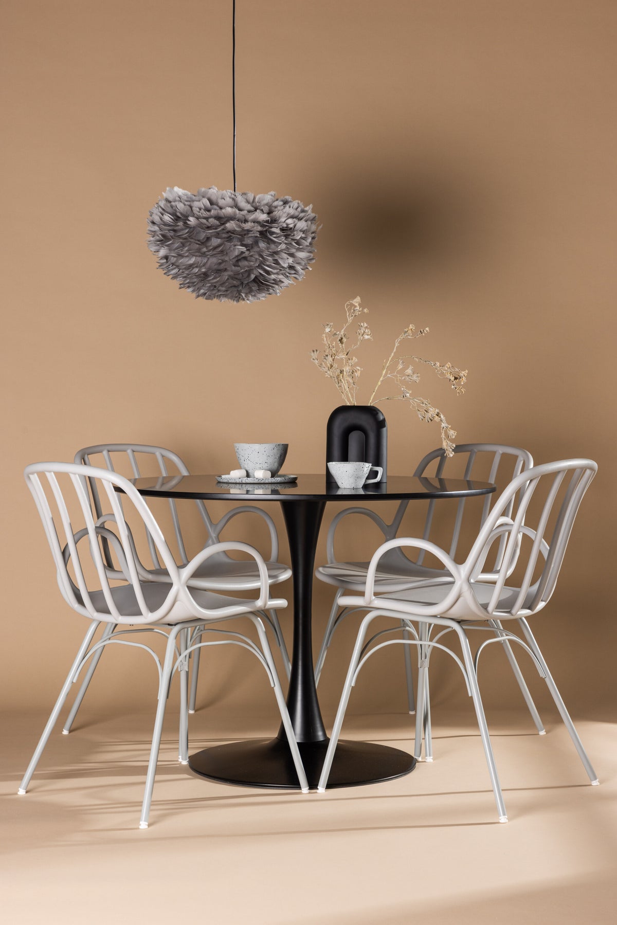 Schwarzes Esszimmerset Glade mit rundem MDF-Tisch und vier Dyrön-Stühlen aus Kunststoff und Stahl, skandinavisches Design.